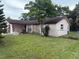 Side view of a single-story home with stone facade and chain link fence at 8516 Inwood Dr, Hudson, FL 34667