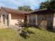 Exterior view of home featuring a stone facade, arched entryway, and a well-maintained lawn at 8516 Inwood Dr, Hudson, FL 34667
