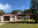 Charming one-story home with a one-car garage, gated entry, stone accents, and a well-manicured lawn at 8516 Inwood Dr, Hudson, FL 34667