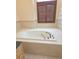 Large bathtub with tiled surround and a shuttered window in a well-lit bathroom at 9188 Mississippi Run, Weeki Wachee, FL 34613
