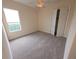 Bright bedroom features plush carpet, a window, and a double-door closet at 9188 Mississippi Run, Weeki Wachee, FL 34613