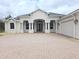 Elegant home exterior with a brick driveway, arched entrance, and well-maintained landscaping at 9188 Mississippi Run, Weeki Wachee, FL 34613