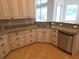 Efficient kitchen with stainless steel dishwasher, custom cabinets, and granite countertops at 9188 Mississippi Run, Weeki Wachee, FL 34613