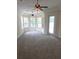 Cozy living area with large windows, ceiling fans, and an exterior door at 9188 Mississippi Run, Weeki Wachee, FL 34613