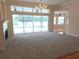 Open-concept living room with neutral carpet, fireplace, and views of the pool at 9188 Mississippi Run, Weeki Wachee, FL 34613