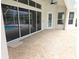 A spacious, covered patio with large sliding glass doors overlooking the screened pool area at 9188 Mississippi Run, Weeki Wachee, FL 34613