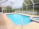 Screened pool and spa with light brick patterned deck and a picturesque view of the lake at 9188 Mississippi Run, Weeki Wachee, FL 34613