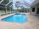 A pristine pool and spa are surrounded by a screened enclosure and paver deck at 9188 Mississippi Run, Weeki Wachee, FL 34613