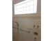 Tiled shower area with grab bars, shower head, and a high window for natural light at 9188 Mississippi Run, Weeki Wachee, FL 34613