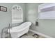 Bright bathroom with a clawfoot tub, tile flooring, and classic design elements at 9212 Calle Alta, New Port Richey, FL 34655