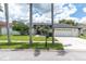 Inviting home with well-manicured lawn, complemented by a pristine white exterior, black trim, and a spacious driveway at 9212 Calle Alta, New Port Richey, FL 34655