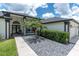 Charming home featuring an arched window above the double door entry and manicured landscaping at 9212 Calle Alta, New Port Richey, FL 34655