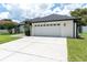 Exterior shot showcasing the two car garage and white exterior with black trim at 9212 Calle Alta, New Port Richey, FL 34655