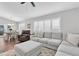 Open-concept living room with gray sectional, ceiling fan, and adjacent dining area at 9212 Calle Alta, New Port Richey, FL 34655