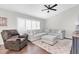 Inviting living room with a gray sectional sofa, ceiling fan, and comfortable armchair at 9212 Calle Alta, New Port Richey, FL 34655