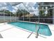 Sparkling blue pool surrounded by a screened enclosure and lush landscaping at 9212 Calle Alta, New Port Richey, FL 34655
