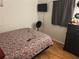 Simple bedroom with a floral patterned bedspread, dark wood dresser, and a wall-mounted TV at 9536 Mayson St, New Port Richey, FL 34654