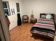 Small, cozy bedroom with a striped bedspread, and a window with a guitar case in the corner at 9536 Mayson St, New Port Richey, FL 34654