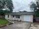 Charming single-story home featuring a well-maintained front yard and a one car garage with a paved driveway at 9536 Mayson St, New Port Richey, FL 34654