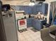 Functional kitchen with blue cabinets, white appliances, tile floors, and a view of the backyard at 9536 Mayson St, New Port Richey, FL 34654