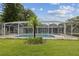 Landscaped backyard showcasing the pool and screened enclosure at 2827 Oak Tree Ln, Palm Harbor, FL 34684