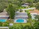 Aerial view of a private backyard with screened-in pool and lush greenery at 2827 Oak Tree Ln, Palm Harbor, FL 34684