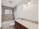 Bathroom featuring stone vanity with dark wood cabinets, bathtub and shower with tiled walls and flooring at 2827 Oak Tree Ln, Palm Harbor, FL 34684