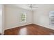 Bright bedroom with hardwood floors, ceiling fan, and two windows offering natural light at 2827 Oak Tree Ln, Palm Harbor, FL 34684