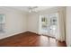 Bright bedroom features wood floors and French doors with backyard views at 2827 Oak Tree Ln, Palm Harbor, FL 34684