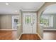 Warm and welcoming foyer with wood flooring, and a white door with decorative glass inlays at 2827 Oak Tree Ln, Palm Harbor, FL 34684