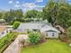 Well-maintained single-Gathering home with mature trees, lush landscaping, and a gray exterior at 2827 Oak Tree Ln, Palm Harbor, FL 34684