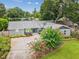 Charming single-story home with well-manicured landscaping, colorful flower beds, and a welcoming entrance at 2827 Oak Tree Ln, Palm Harbor, FL 34684