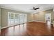 Spacious living room with hardwood floors, a ceiling fan, and glass doors leading to the pool area at 2827 Oak Tree Ln, Palm Harbor, FL 34684