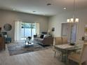 Open living room and dining area with tile floors and access to backyard at 593 Azure Rd, Venice, FL 34293