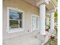 Inviting front porch featuring sturdy columns, a window, and a white front door at 2781 Shady Ave, North Port, FL 34286