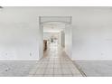 Spacious living room with tiled floors and an arched opening to the kitchen area at 2781 Shady Ave, North Port, FL 34286
