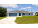 Beautiful single-story home featuring a gray finish, concrete tile driveway, and well-kept lawn at 310 Day Break Cir, Port Charlotte, FL 33954