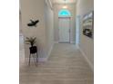 Inviting hallway with neutral tones, light tile flooring and artful decor at 1590 Royal Rd, Venice, FL 34293