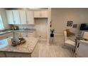 Bright kitchen and dining area with a cozy dining area and view to the living room at 1590 Royal Rd, Venice, FL 34293