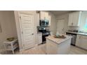 Bright kitchen featuring white cabinets, granite countertops and stainless steel appliances at 1590 Royal Rd, Venice, FL 34293