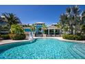 Community pool with a blue tile surface and palm trees at 376 Aruba Cir # 301, Bradenton, FL 34209