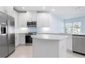 Modern kitchen with white cabinets, island, and stainless steel appliances at 3426 79Th Street W Cir # 202, Bradenton, FL 34209