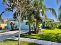Curb appeal! Light blue house with lush tropical landscaping at 11420 Captiva Kay Dr, Riverview, FL 33569