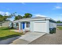 Newly renovated light blue house with a blue door, and a well-manicured lawn at 3875 Pan American Blvd, North Port, FL 34287