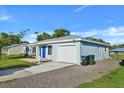 Newly renovated light blue house with a blue door, and a well-manicured lawn at 3875 Pan American Blvd, North Port, FL 34287