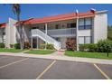 Two story building exterior with red tile roof and white stairs at 1801 Gulf N Dr # 248, Bradenton Beach, FL 34217