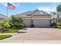 Tan house with a three-car garage and landscaped yard at 27855 Arrowhead Cir, Punta Gorda, FL 33982