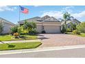 Tan house with a three-car garage and landscaped yard at 27855 Arrowhead Cir, Punta Gorda, FL 33982