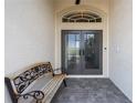 Inviting entryway with double doors, decorative glass, and a wooden bench at 855 Boundary Blvd, Rotonda West, FL 33947