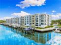 Beautiful waterfront apartment complex with boat docks on a sunny day with a blue sky and white clouds at 1709 N Tamiami Trl # 403, Sarasota, FL 34234